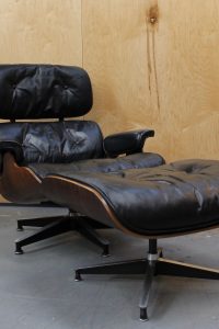 photo of side of rare Eames black leather and rosewood lounge chair