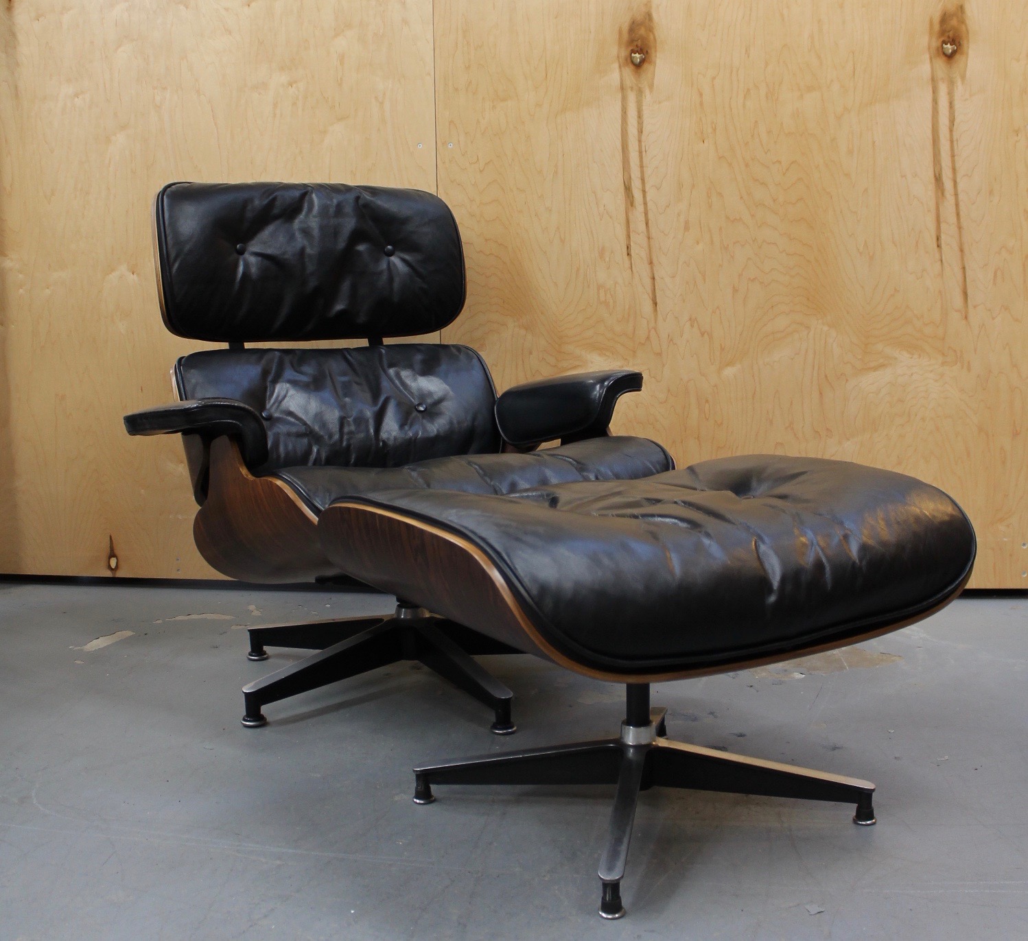 photo of side of rare Eames black leather and rosewood lounge chair