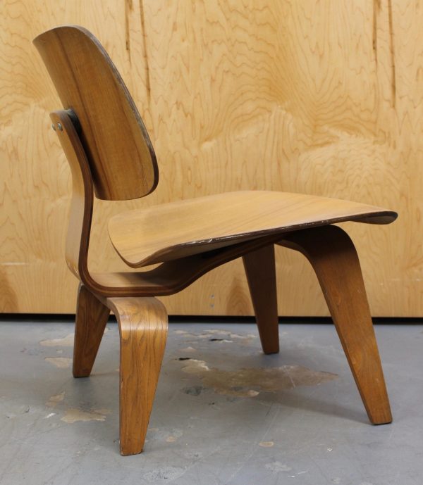 photo of side of light wood 1950s Eames LCW chair