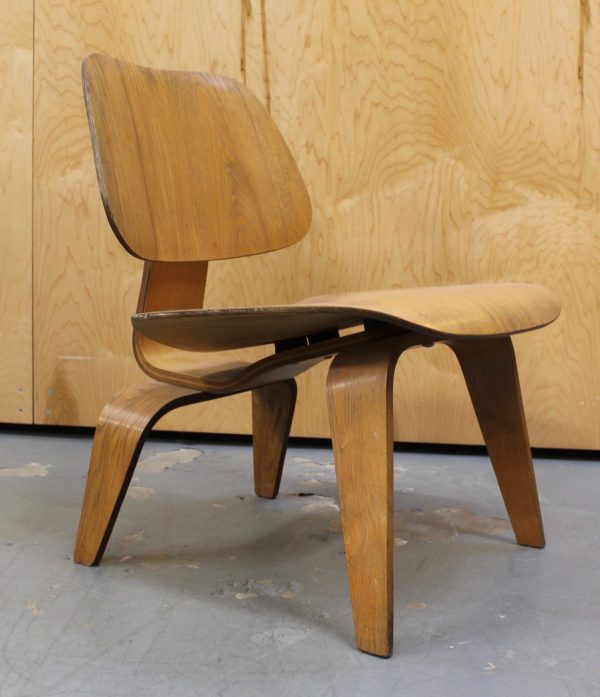 photo of side of light wood 1950s Eames LCW chair