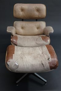 distressed Eames Lounge & Ottoman with torn and taped leather
